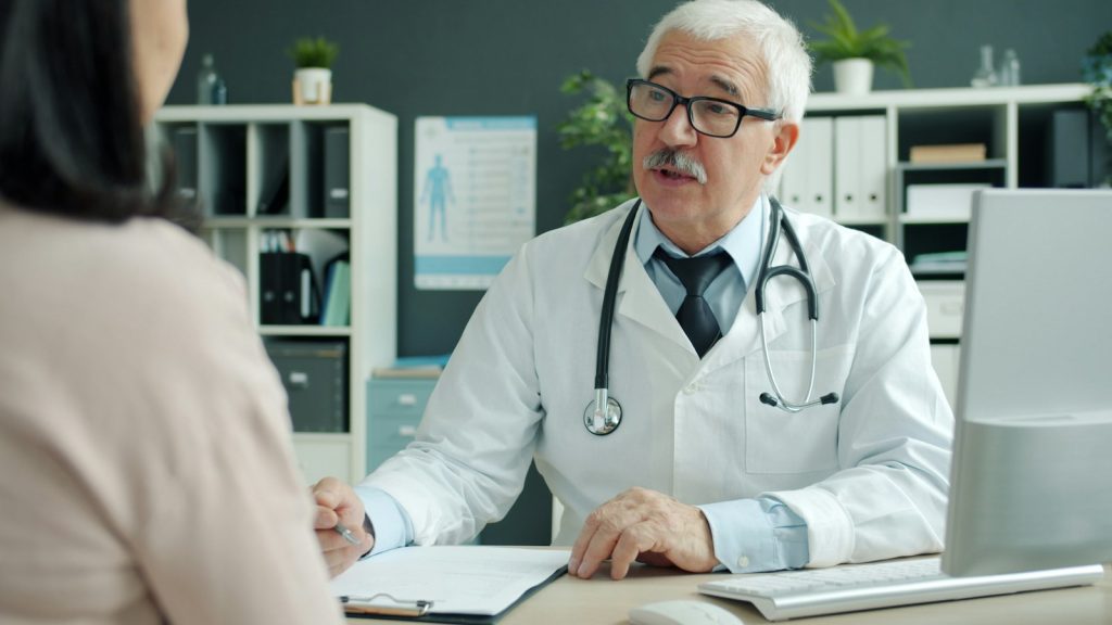 Friendly doctor sitting at his desk